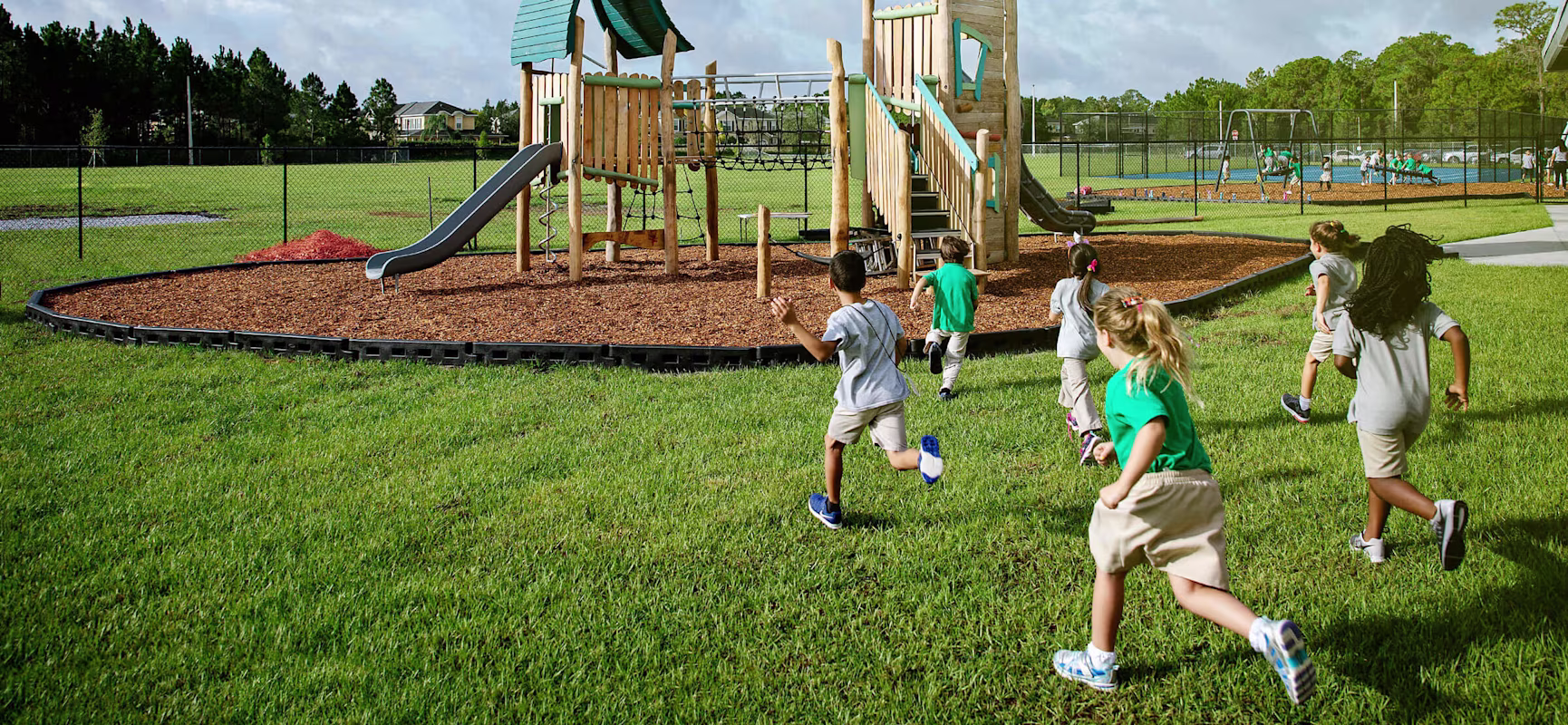 students at North Tampa Christian Academy running towards wooden play tower