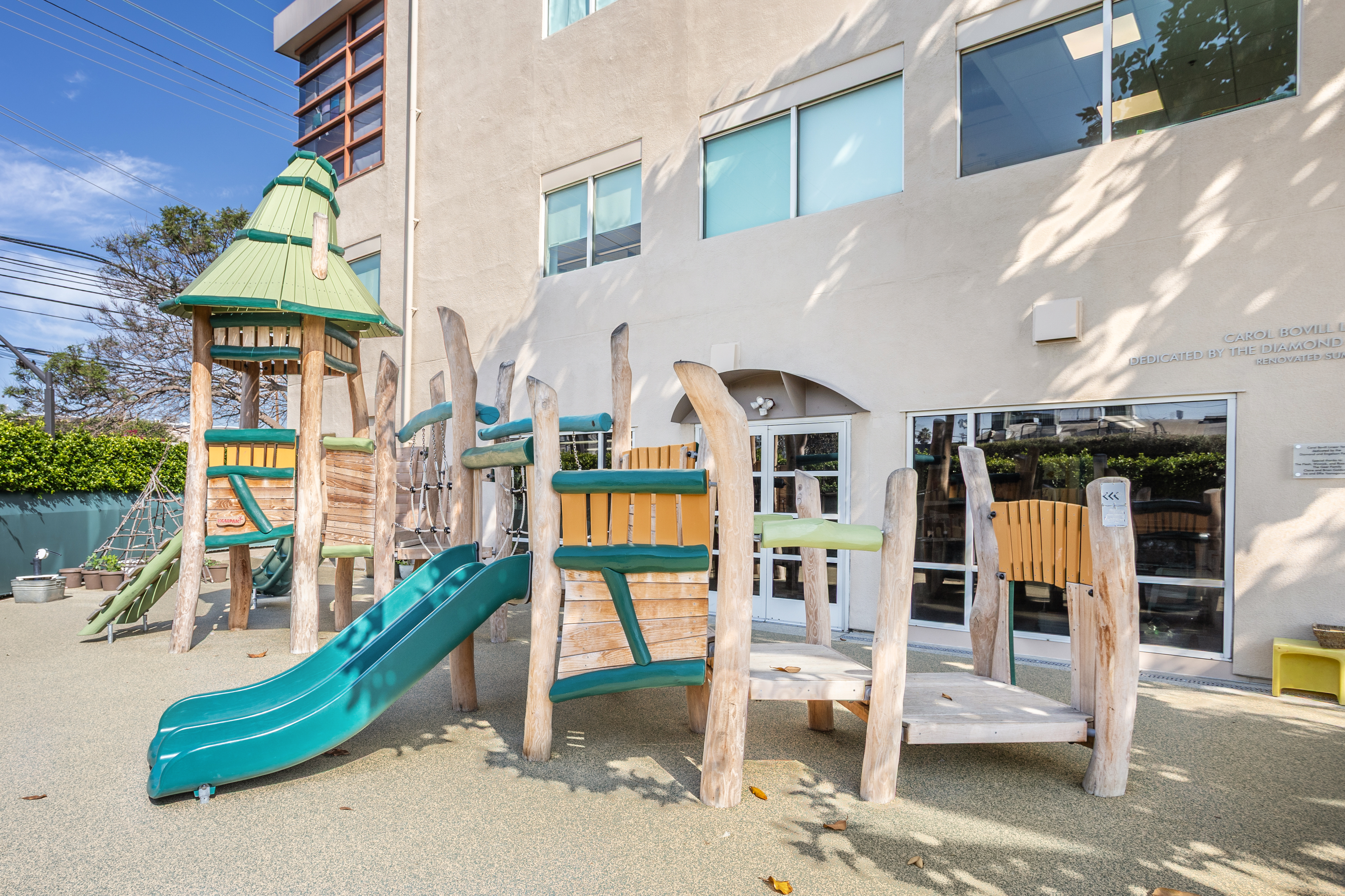 Whimsical wooden play structure at Mann Family Early Childhood Center in Los Angeles, California