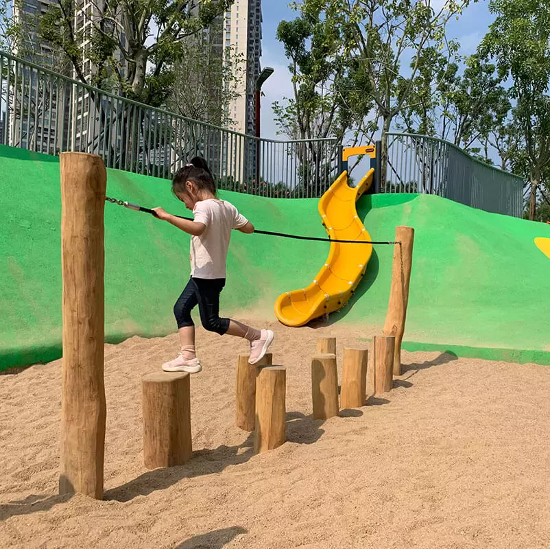 a child playing on a wooden balancing playground reference image