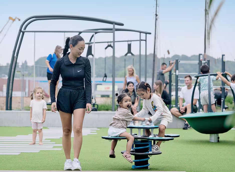 A group of women and children playing on a playground.