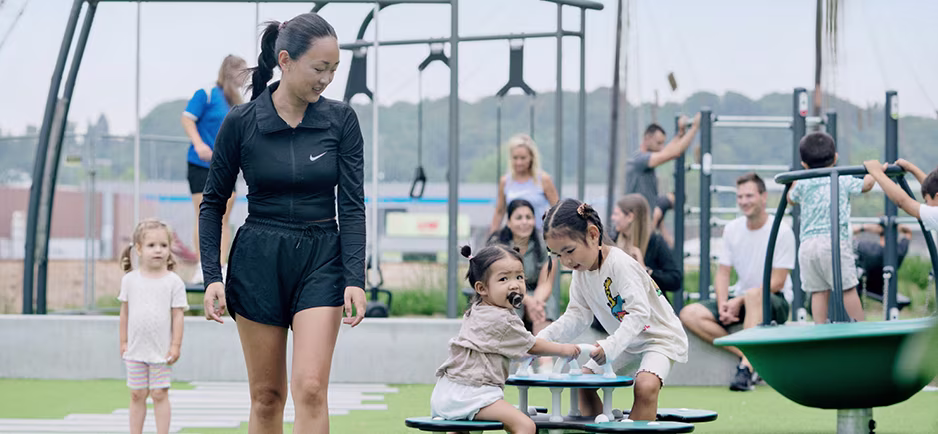 A group of women and children playing on a playground.