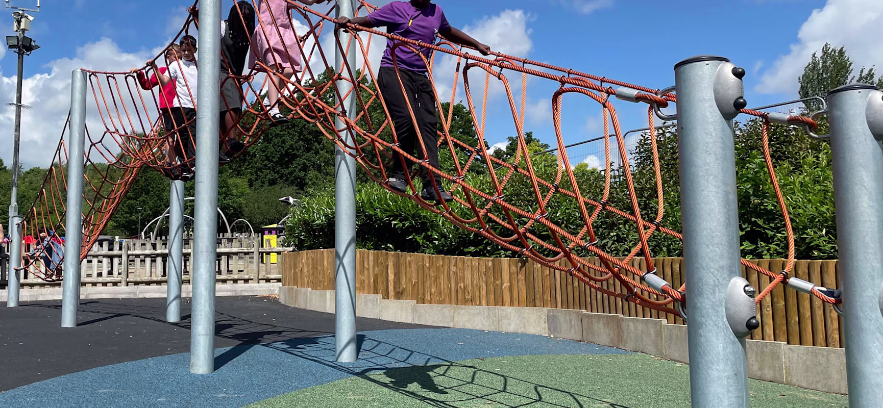 children playing on a rope brigde on a playground