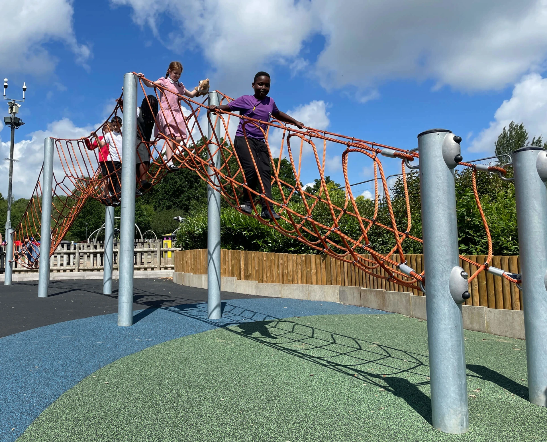 children playing on a rope brigde on a playground