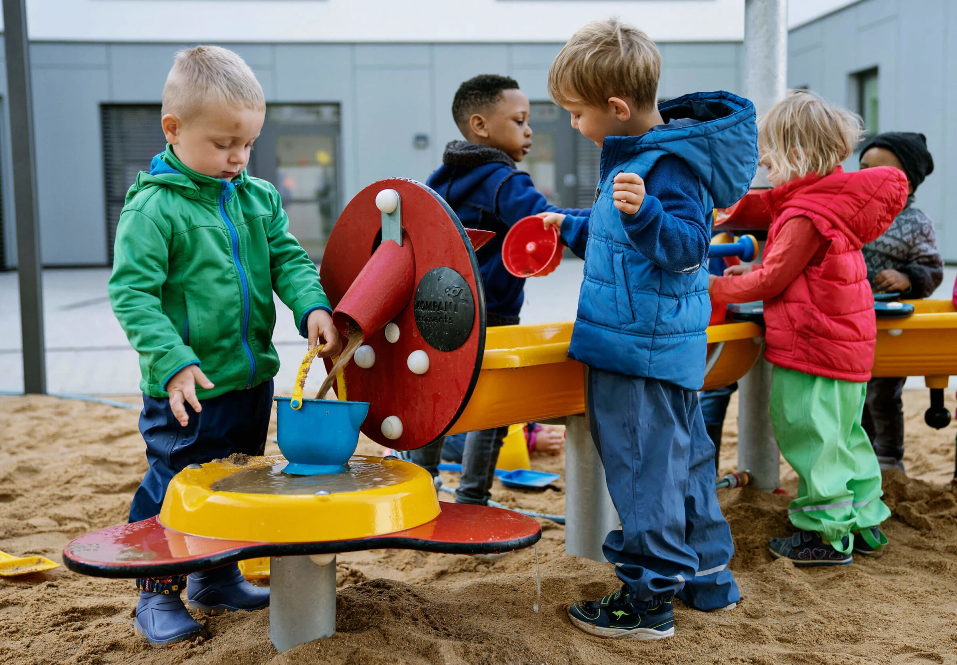 children playing with sand and water games at a kindergarten