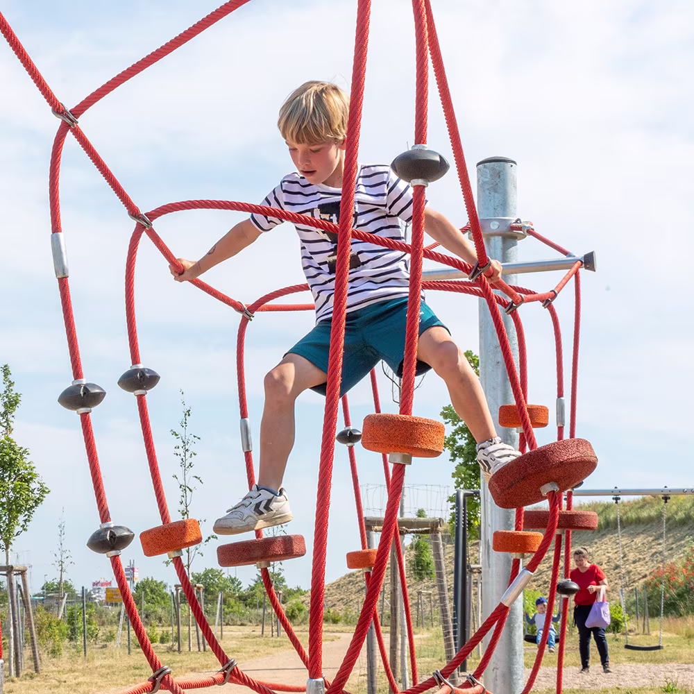 Kind klettert am Seilspielgerät in Barleben, Deutschland