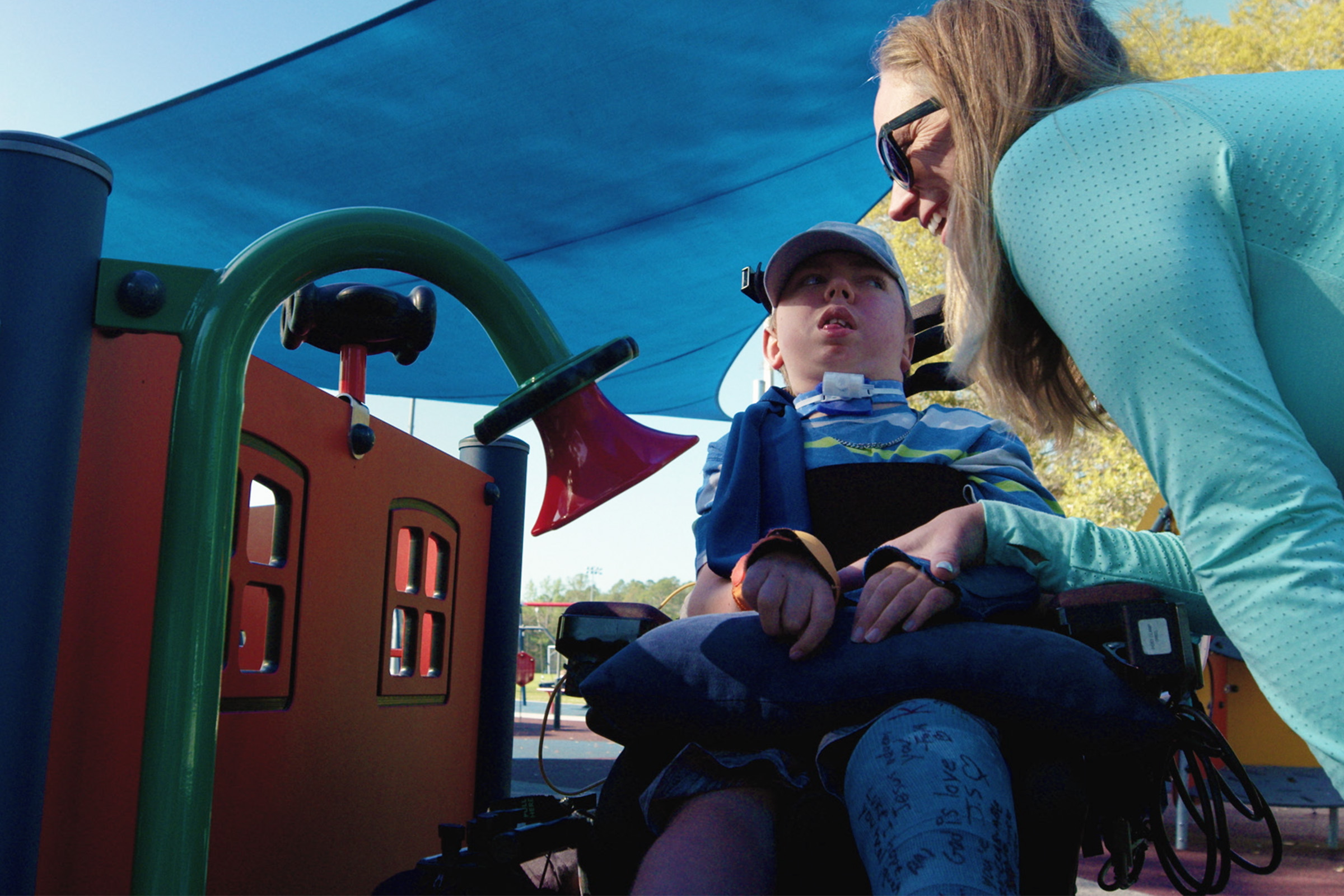 Advocacy Abby and two children at inclusive playground