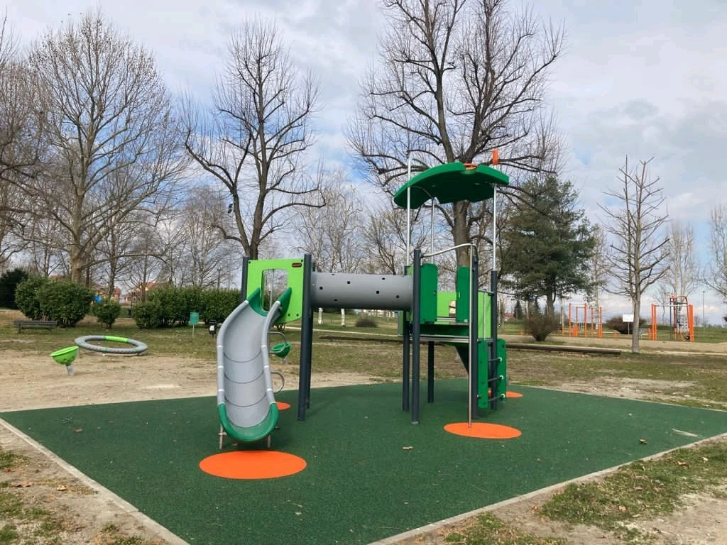 green play system in a park with a slide