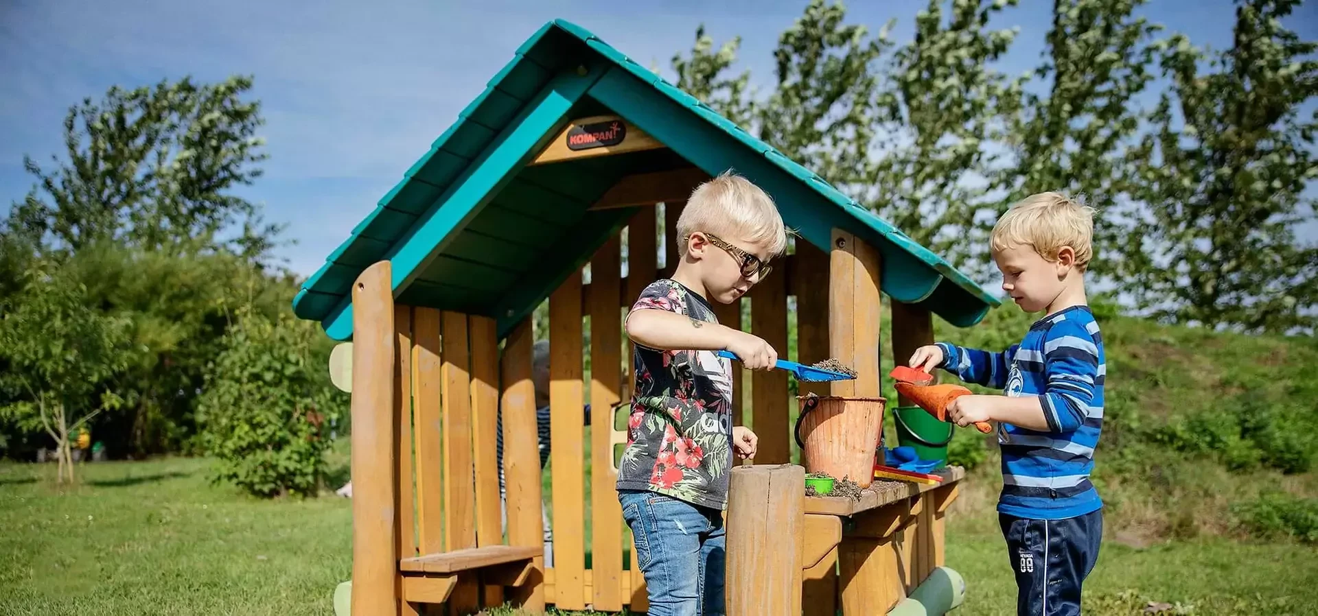 Kinder spielen auf einem Spielhütten- und Spielhäuser-Spielplatz in einem Spielhaus aus Robinie