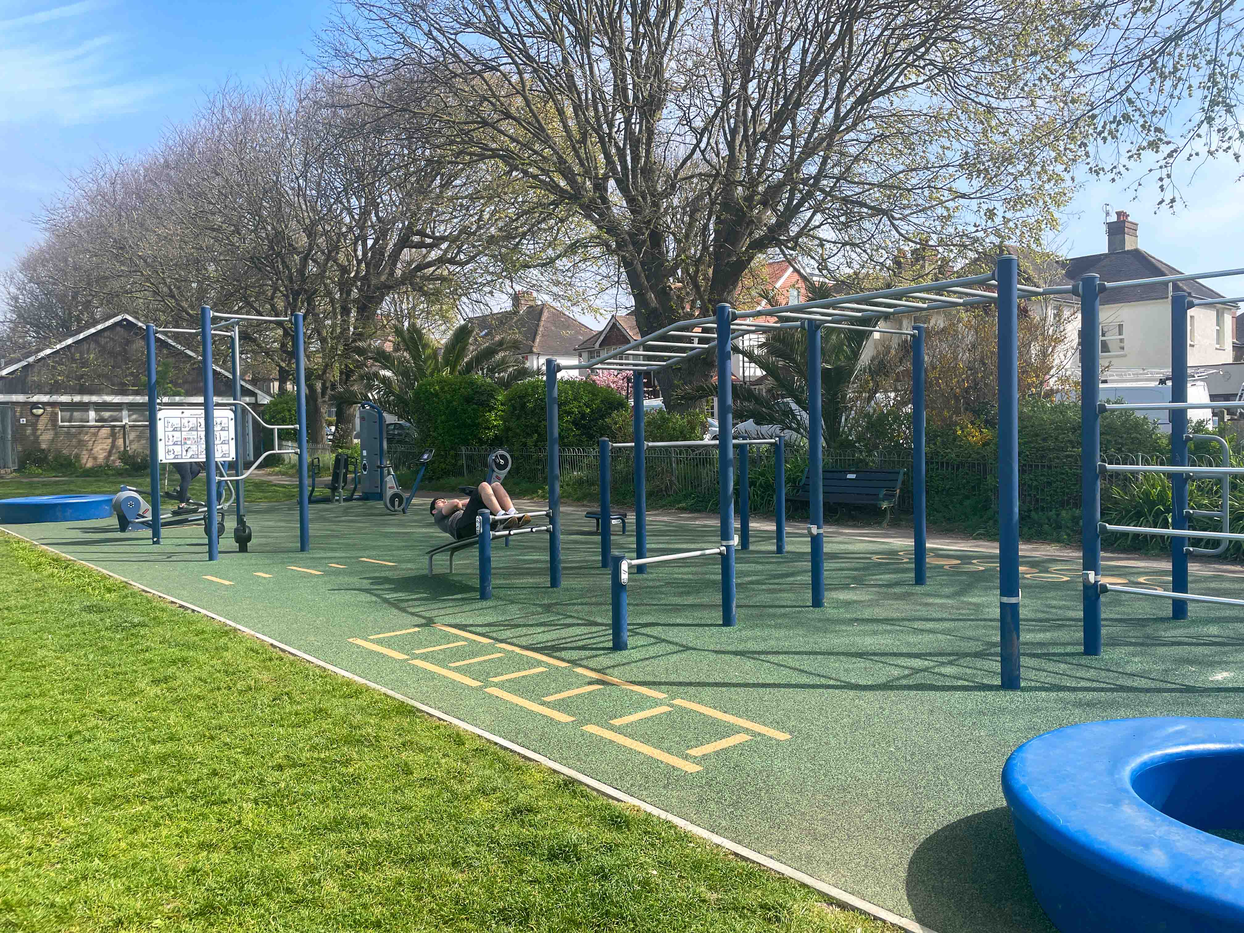 Blue outdoor gym fitness area with bars, kettle bells and sit up bench 