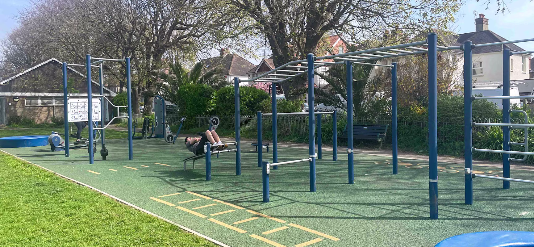 Blue outdoor gym fitness area with bars, kettle bells and sit up bench