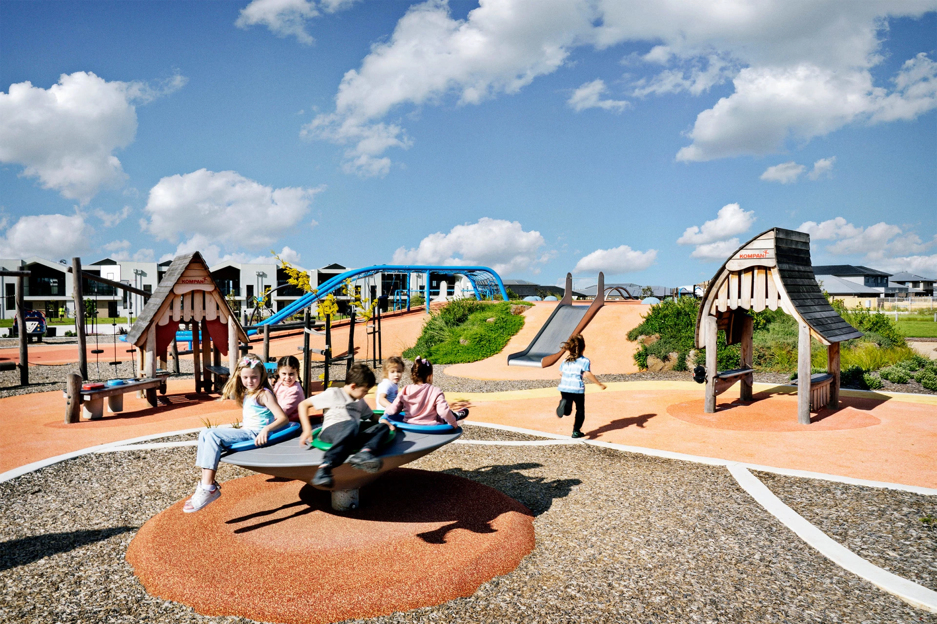 Multiple children playing on a KOMPAN playground in Australia 