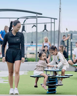 2 girls playing on a springer with fitness equipment in the background