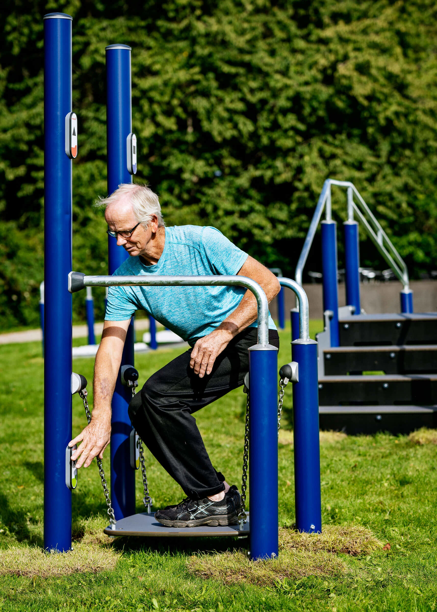 Mann benutzt Outdoor-Fitnessgeräte für Senioren zur Verbesserung des Gleichgewichts