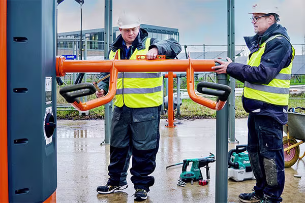 to menn som installerer et utendørs treningsstudio