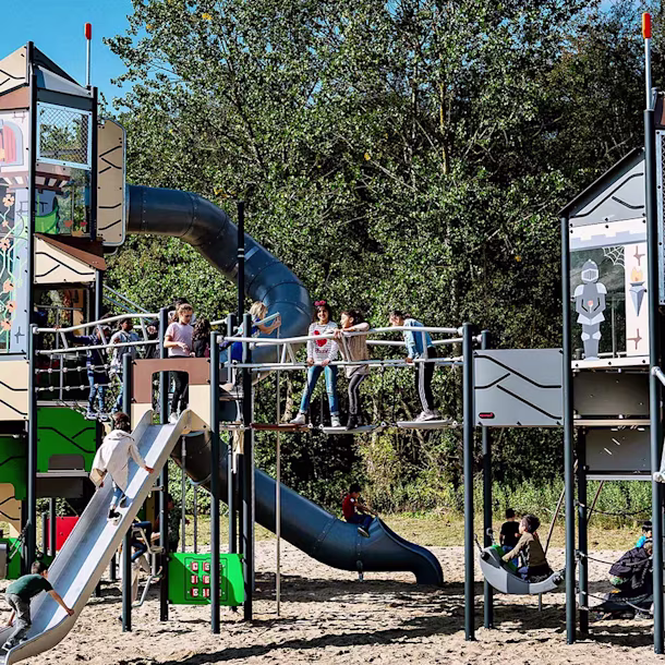 hero image of large play system in a park with school children playing
