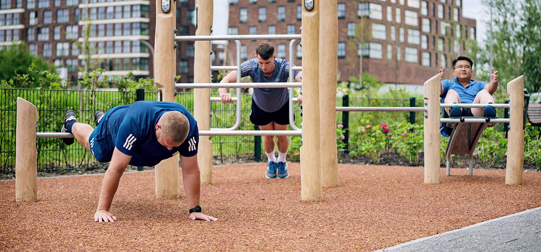 people training on an outdoor gym with wooden fitness equipment hero image