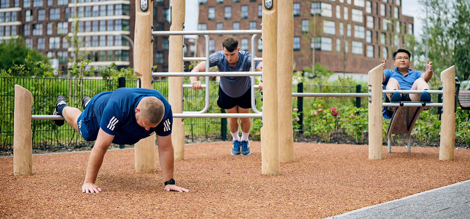 people training on an outdoor gym with wooden fitness equipment hero image