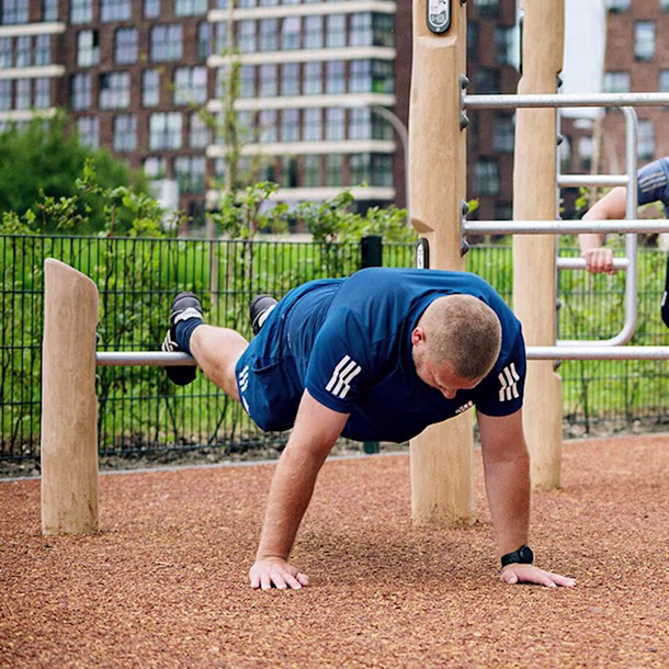people training on an outdoor gym with wooden fitness equipment hero image