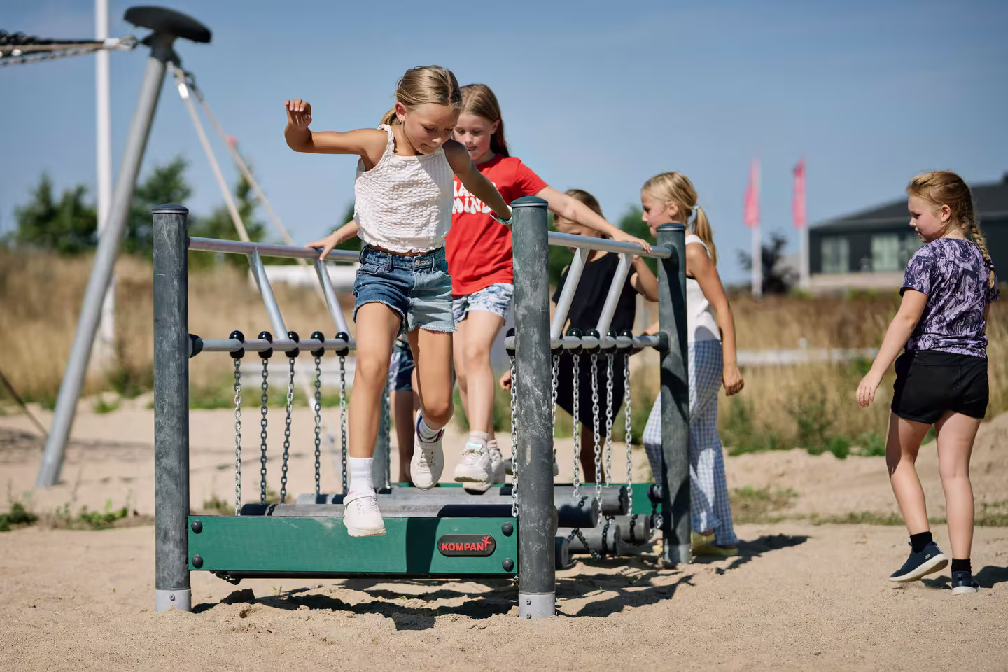 children balancing on balancing and climbing playground equipment