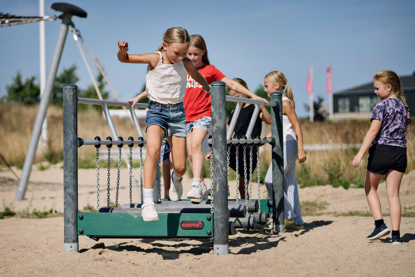children balancing on balancing and climbing playground equipment