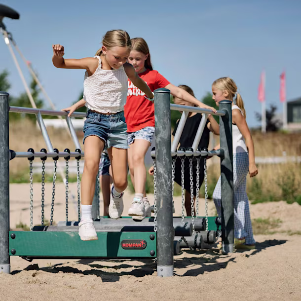 children balancing on balancing and climbing playground equipment