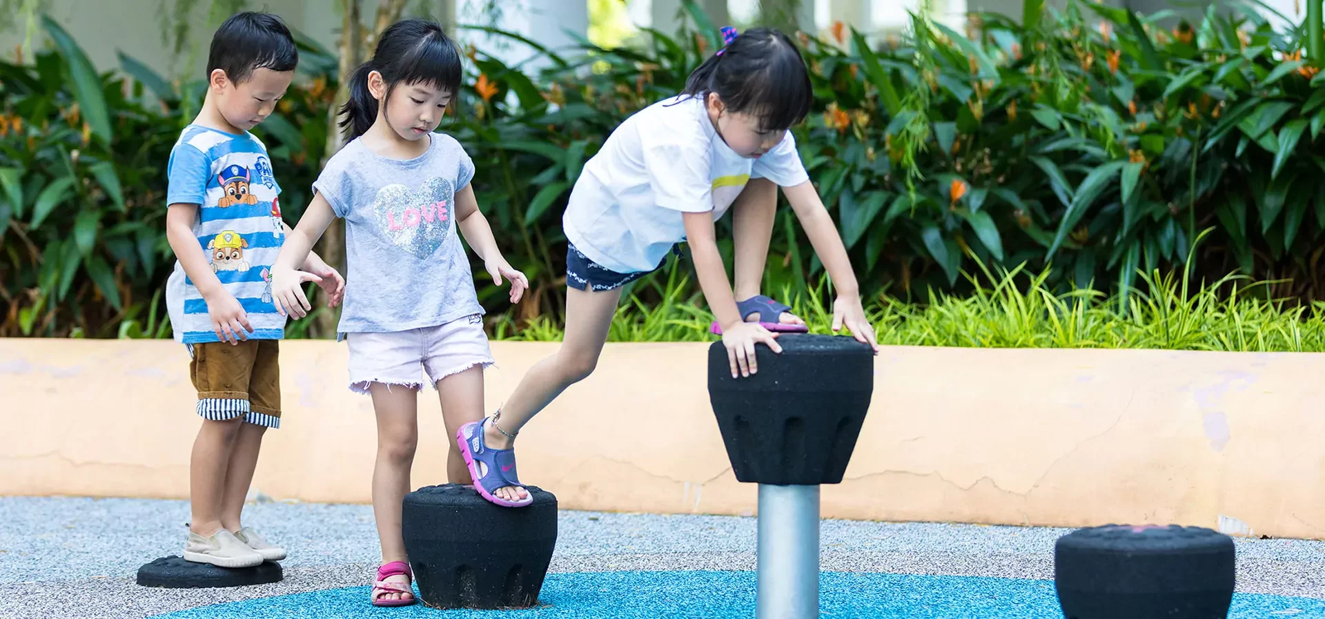 children balancing on balancing and climbing playground equipment