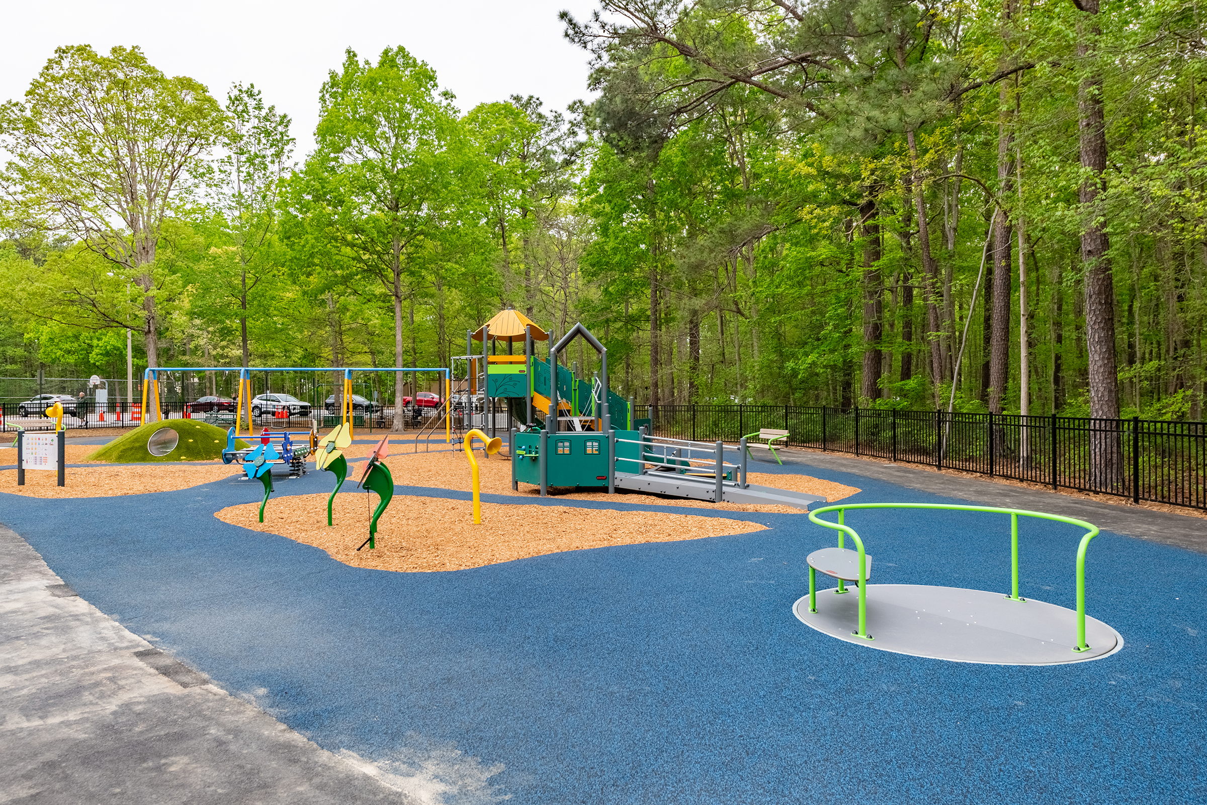 Playground featuring inclusive equipment--carousel, ramps, paths