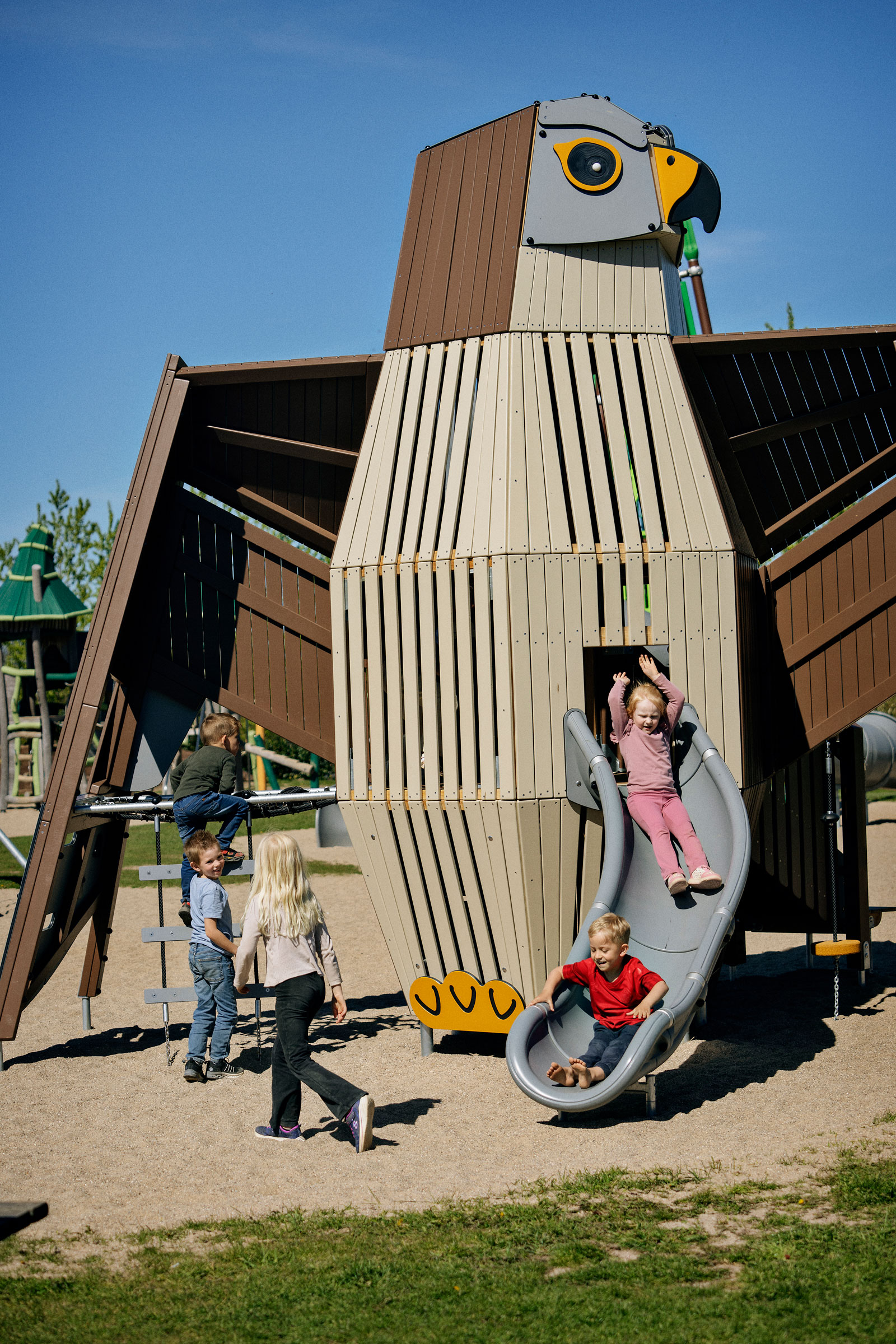 kids playing on a bird playground sculpture