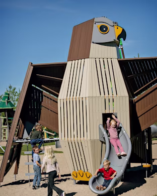kids playing on a bird playground sculpture