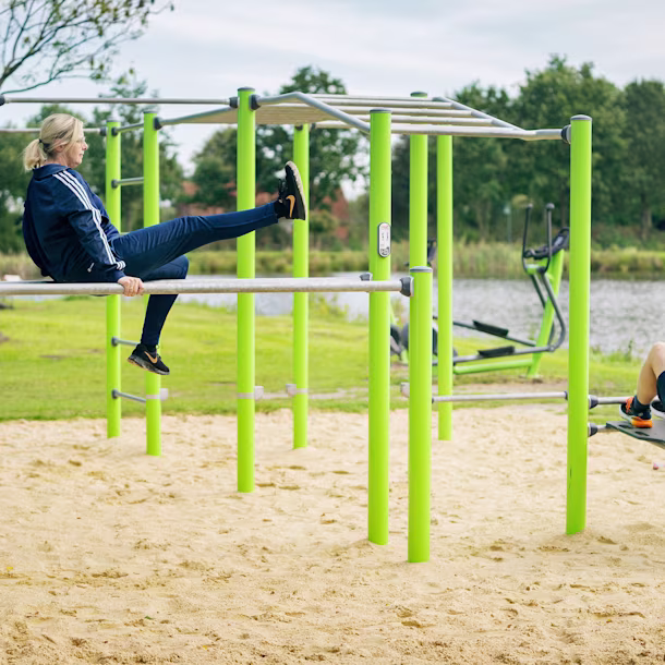 Zwei Personen trainieren gemeinsam an einer Street Workout Calisthenics Anlage