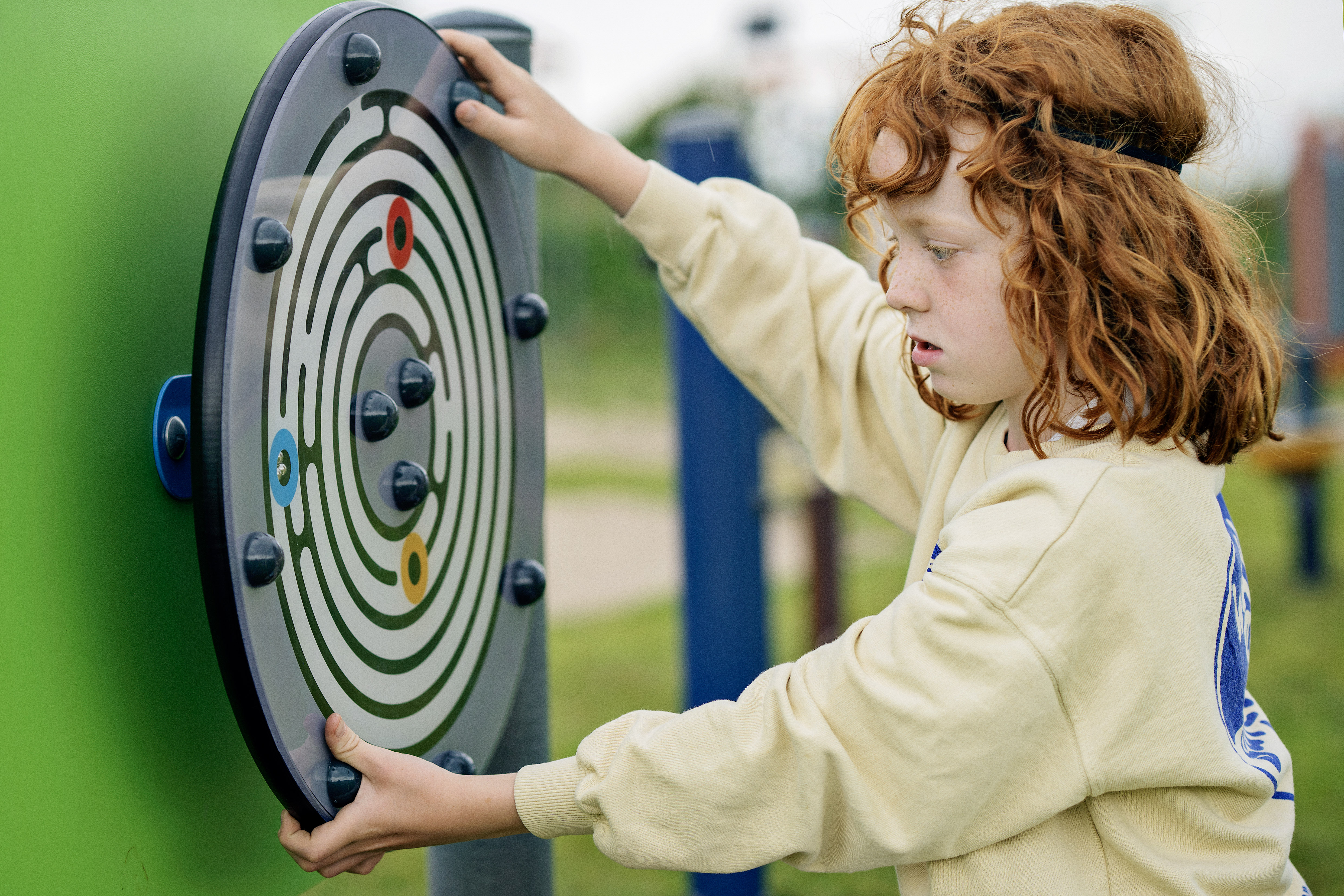 Kind spielt mit KOMPAN Spielwand