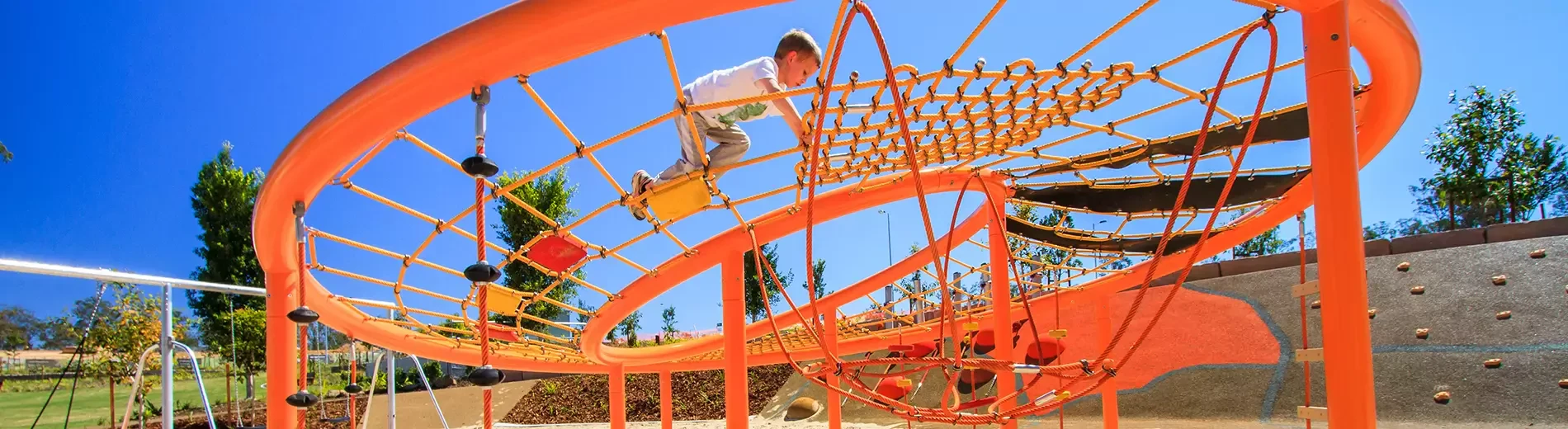 child playing on an orange rope playground corocord loops hero image