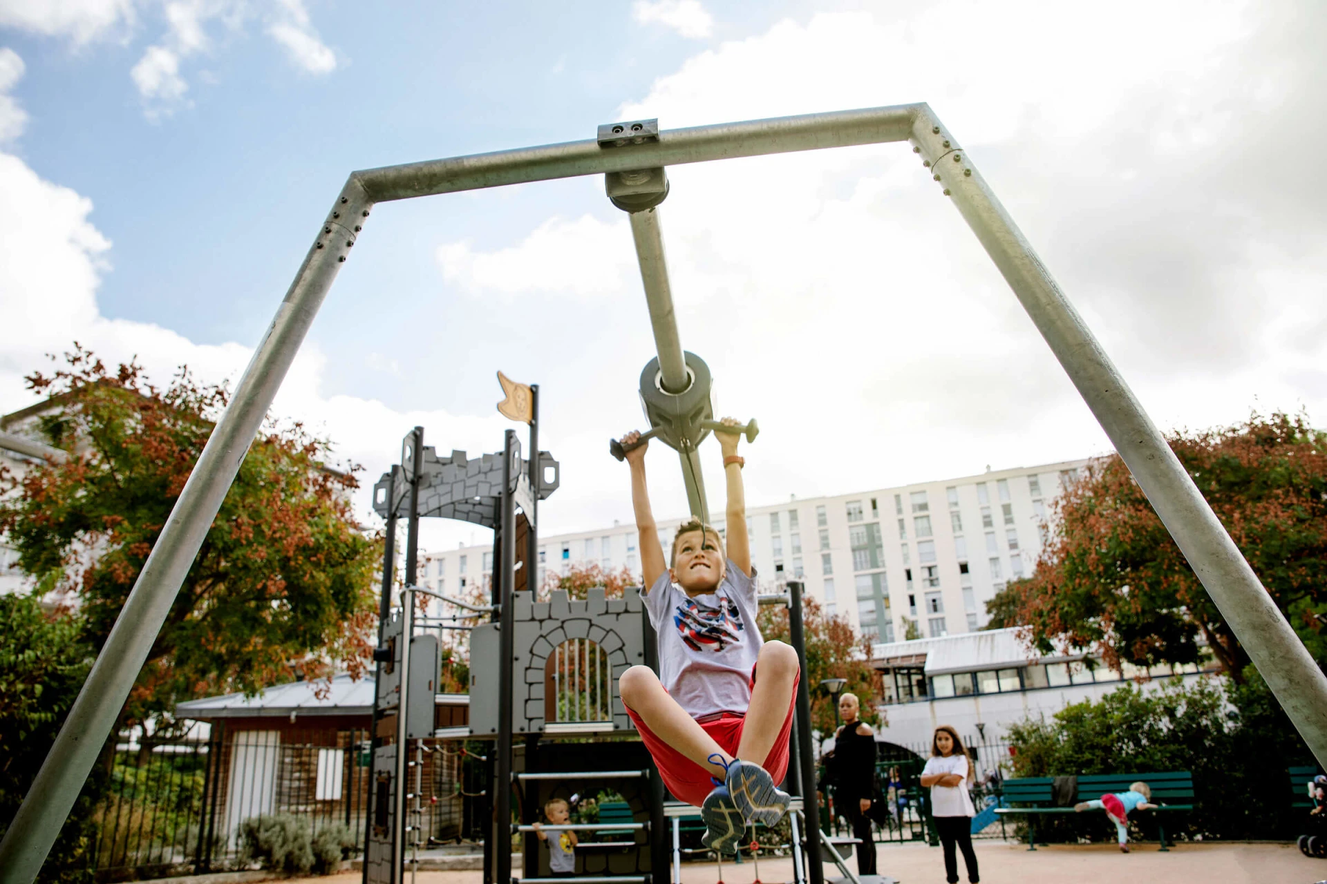 Boy on cableway on a playground in Jardin de la ZAC Didot