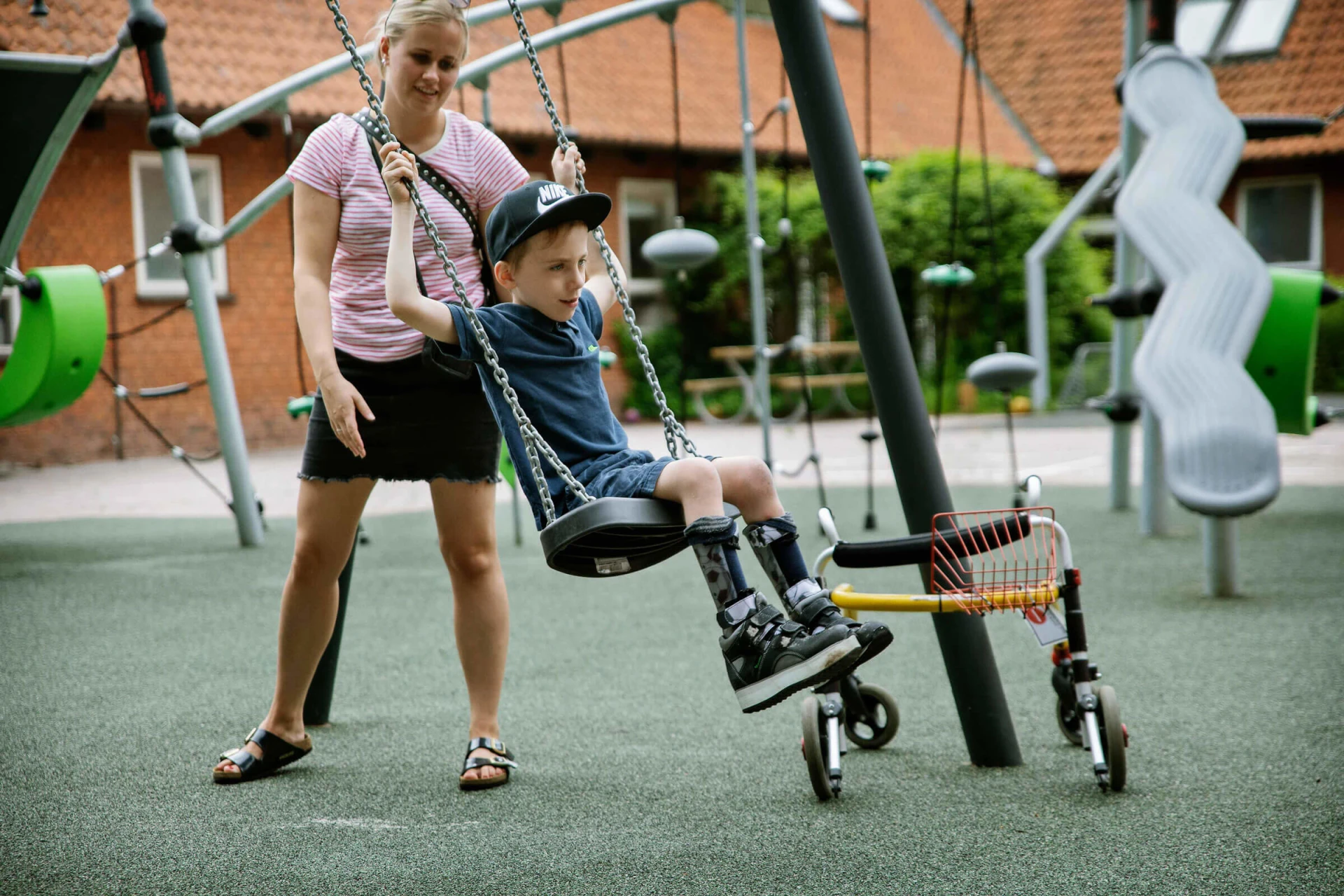 A boy swinging on an inclusive swing set