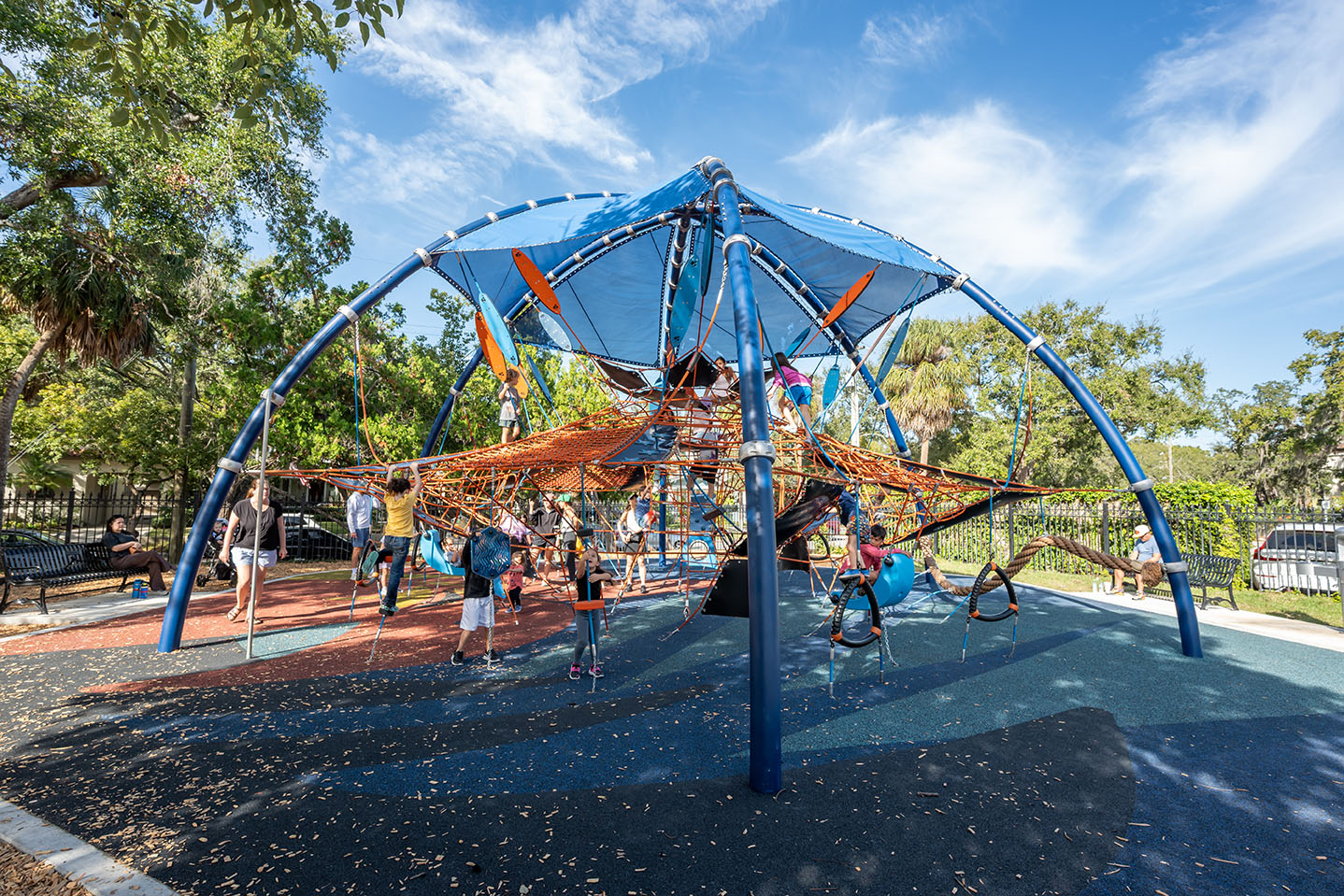 Many children playing on a high-capacity playground climbing structure at Anderson Playground in Tampa, Florida