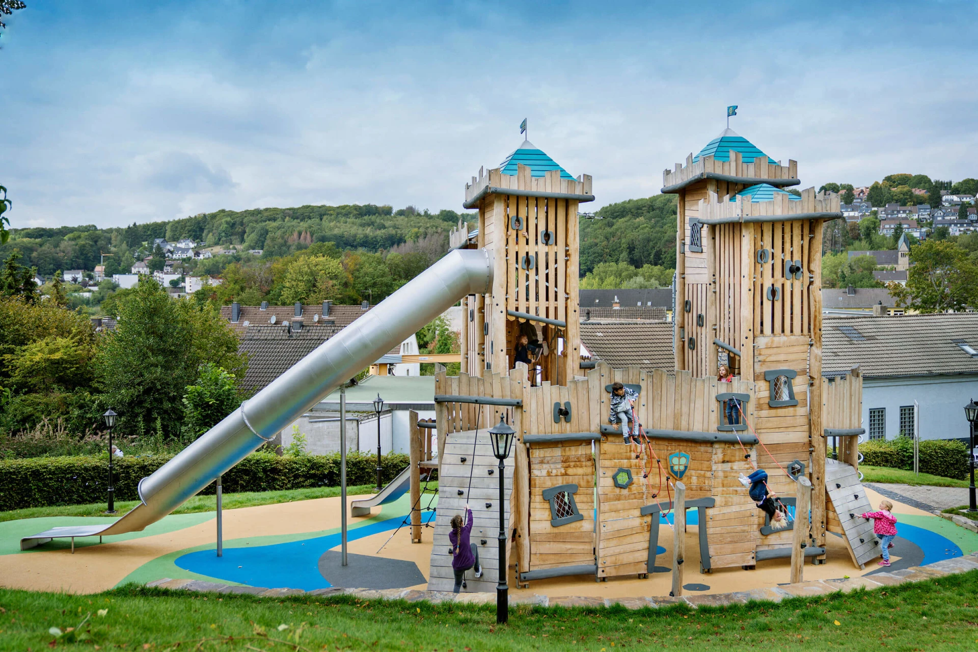 grande parco giochi con castello in legno e scivolo d'ispirazione
