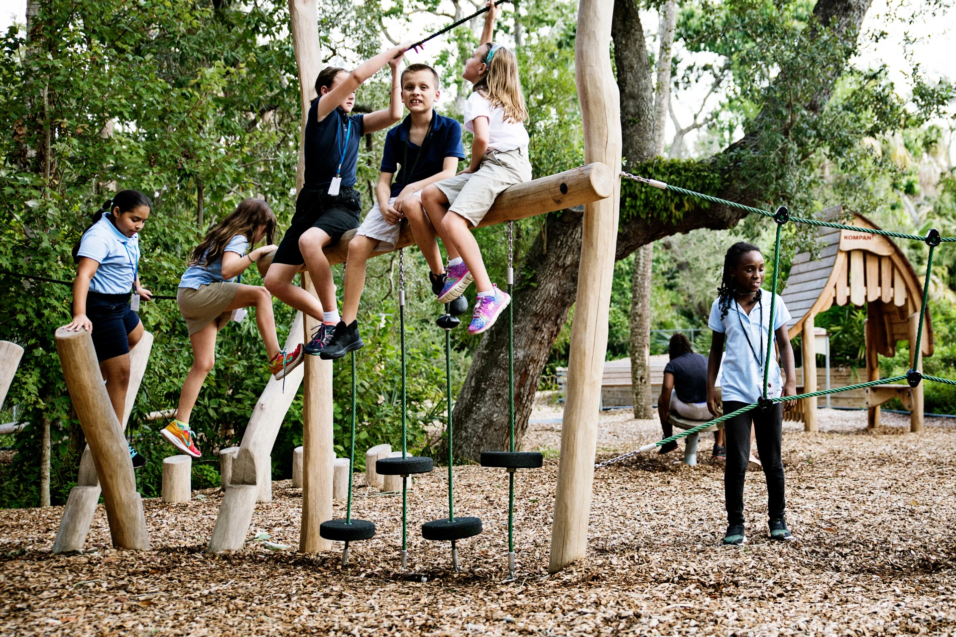 Adventurous children climbing over natural playground structures