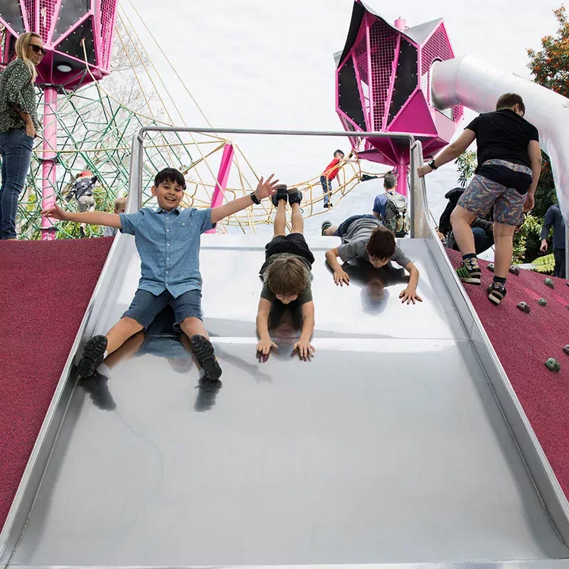 barn åker ner för en rutschkana på en lekplats i Australien