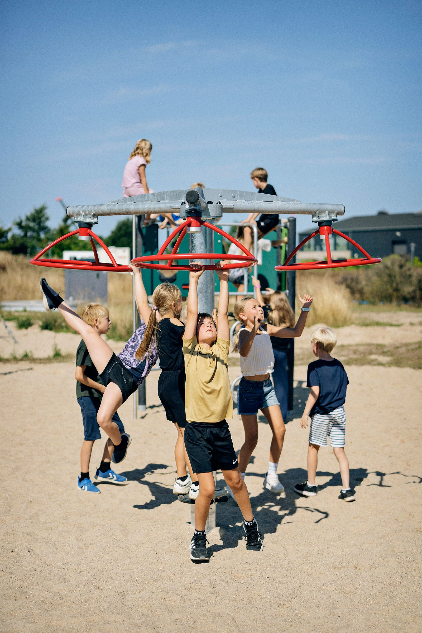 Children playing and working together to spin on playground equipment