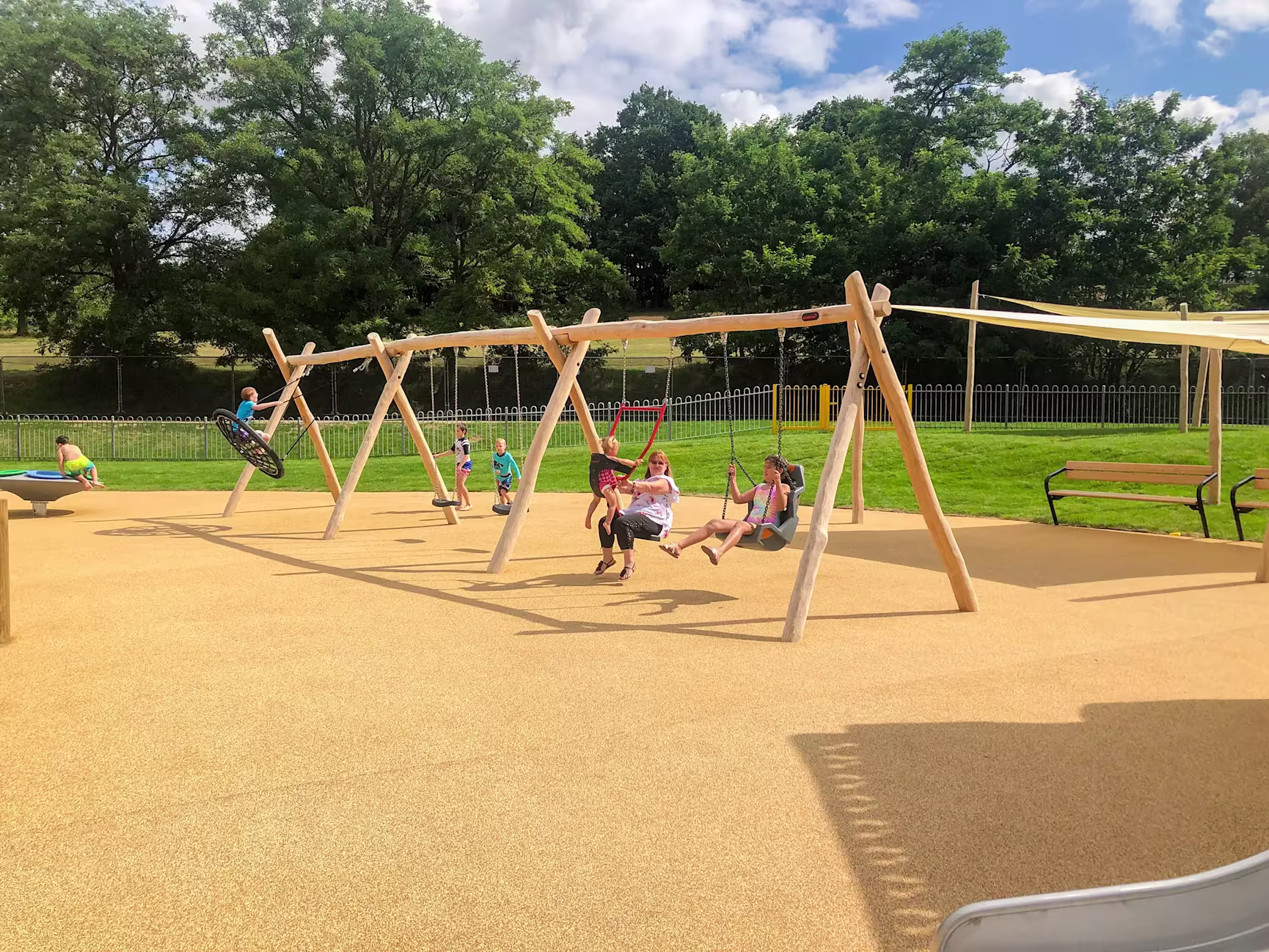 children playing on a wooden swing playground hero image