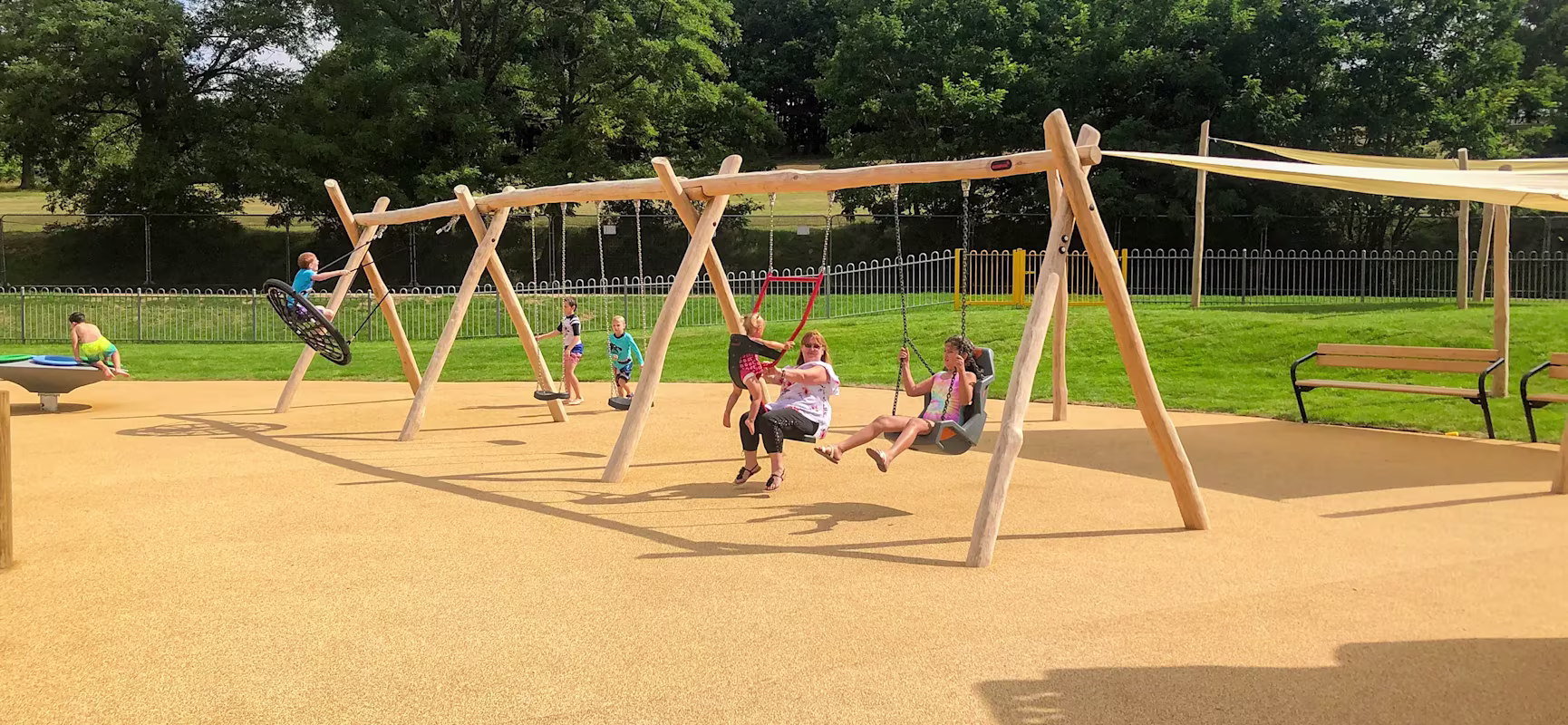 children playing on a wooden swing playground hero image