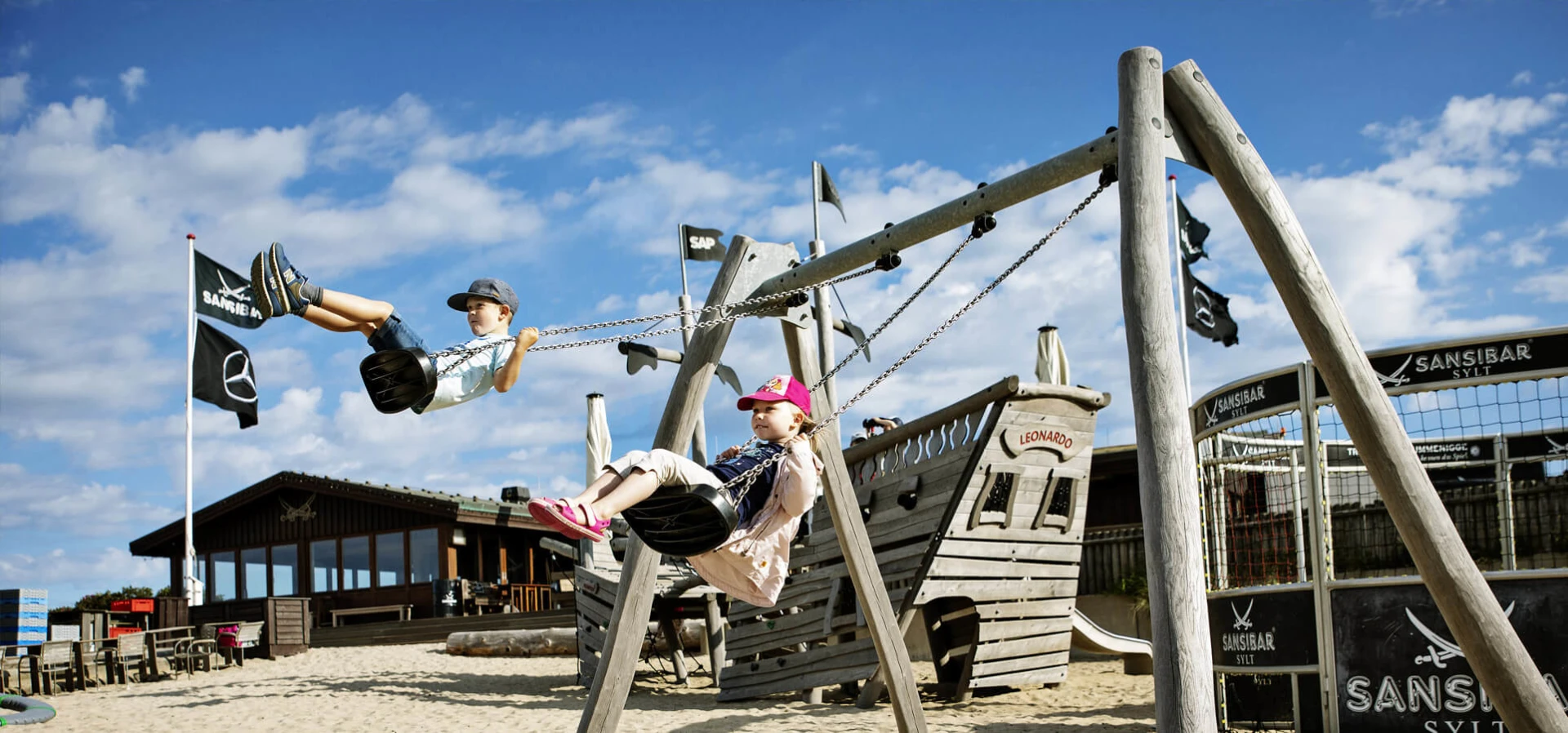 Children playing on a wooden swing set
