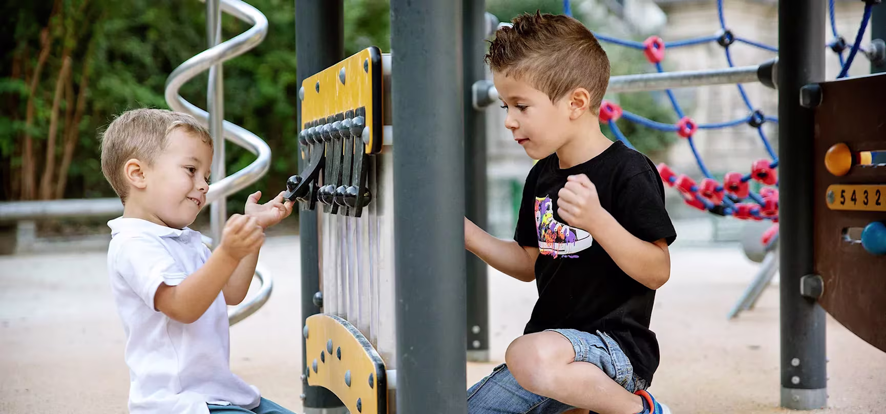children playing on inclusive playground panel at a park
