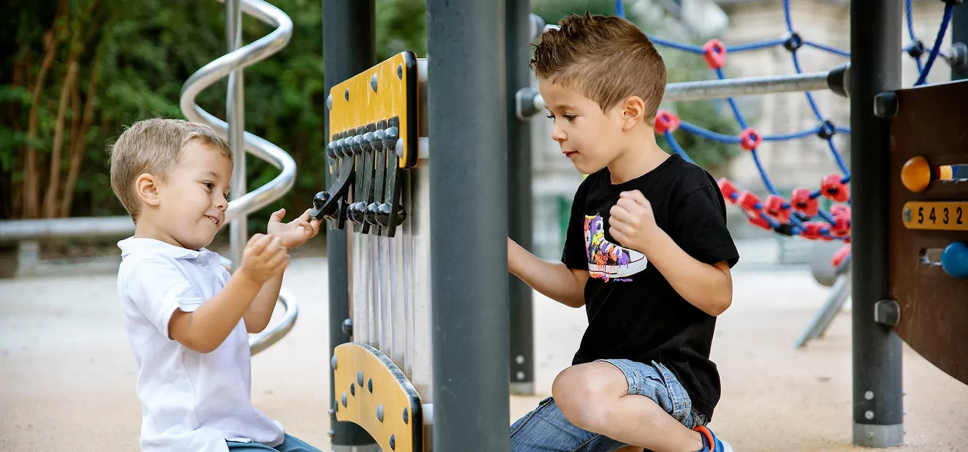 Kinder spielen an einer Spielwand auf einem Spielplatz in einem Park