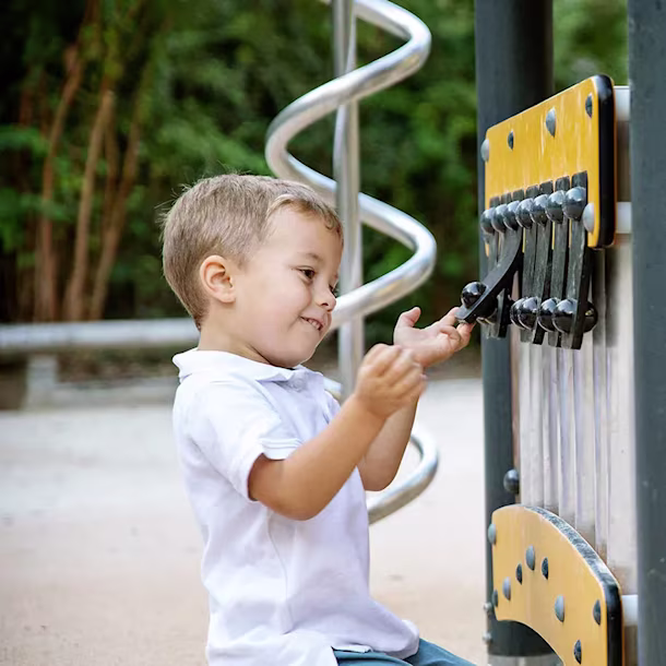 children playing on inclusive playground panel at a park