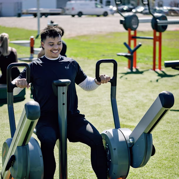 Personnes dans un parc utilisant des machines de musculation en plein air
