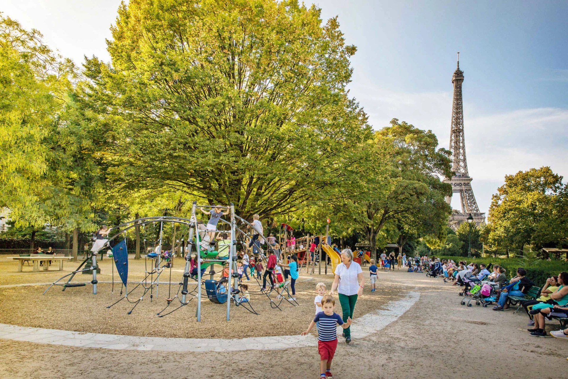 Children and parents at a KOMPAN playground by the Eiffel Tower