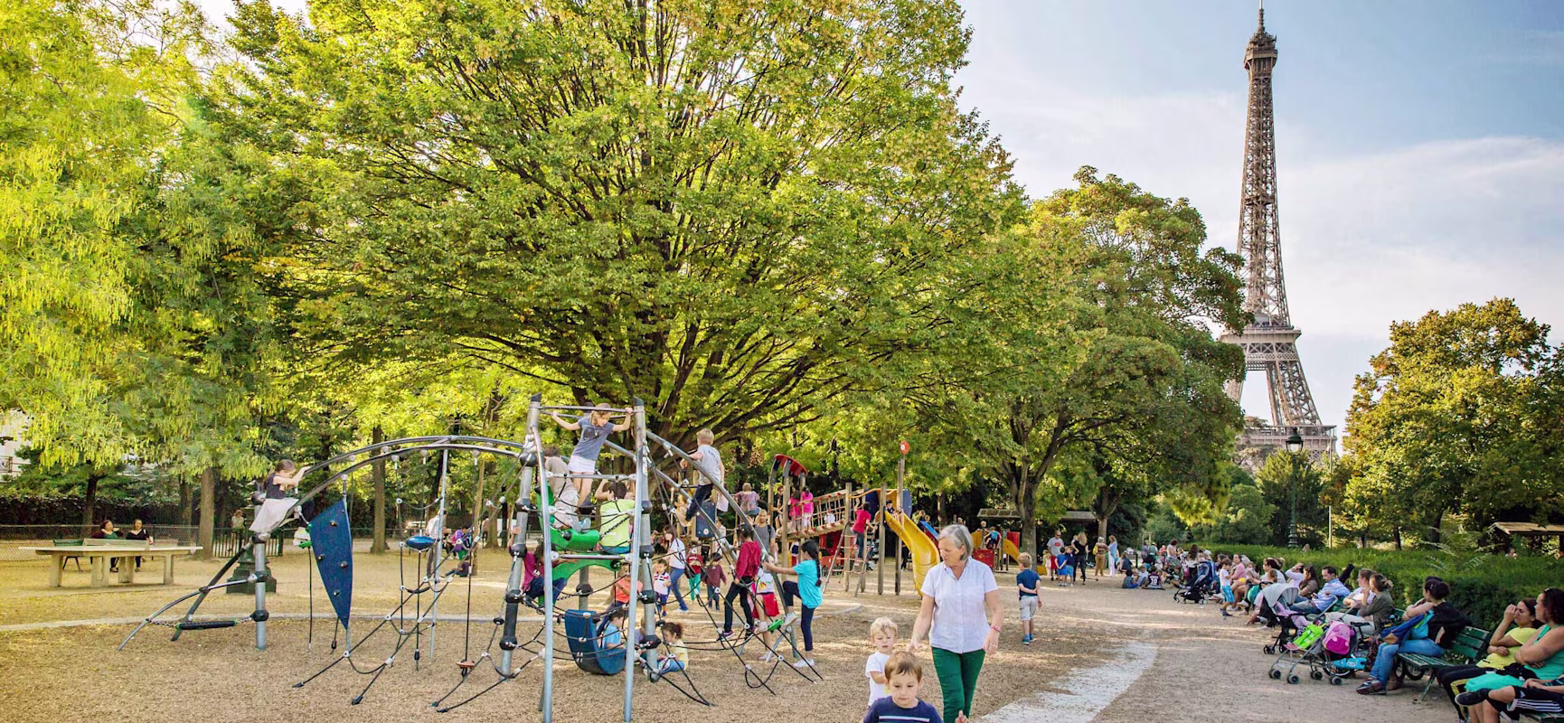 Children and parents at a KOMPAN playground by the Eiffel Tower