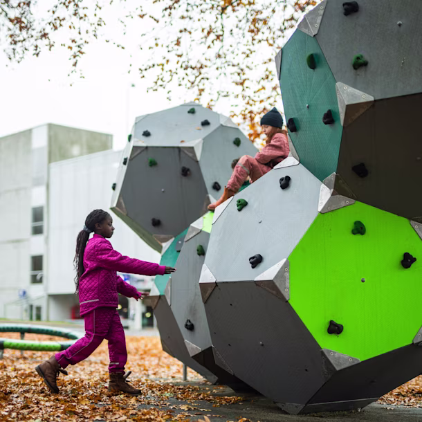 dos niñas trepando om parque infantil climbing bloqx