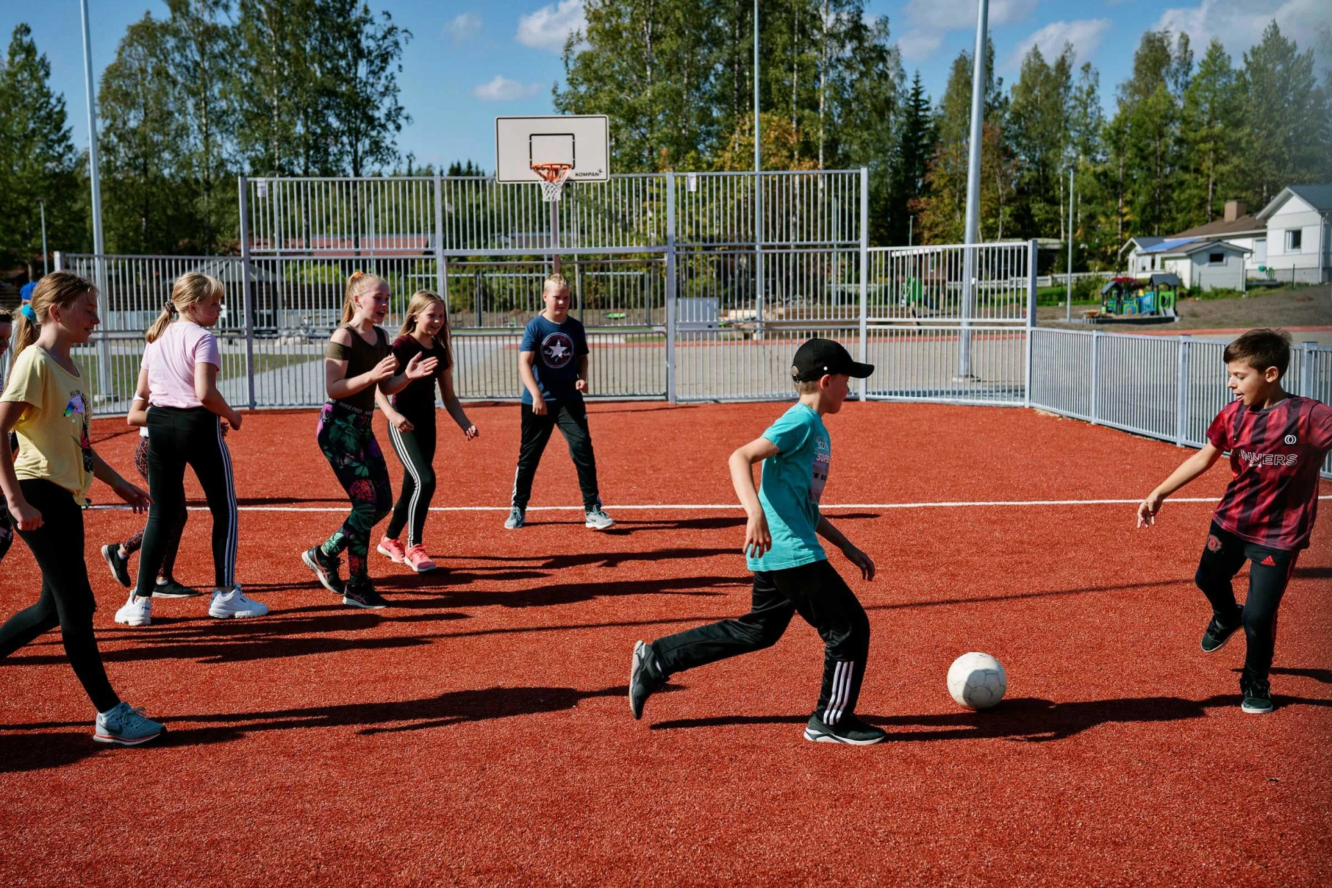Kids playing soccer on an outdoor multisport court